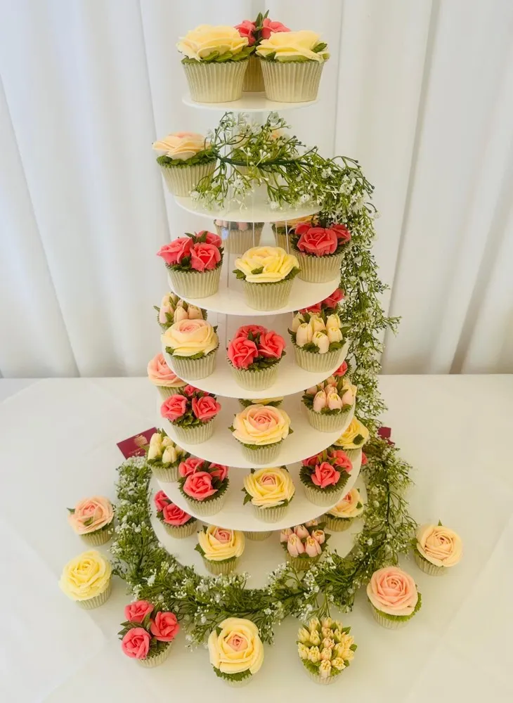 Seven-tier wedding cupcake tower with peach, coral and cream buttercream roses